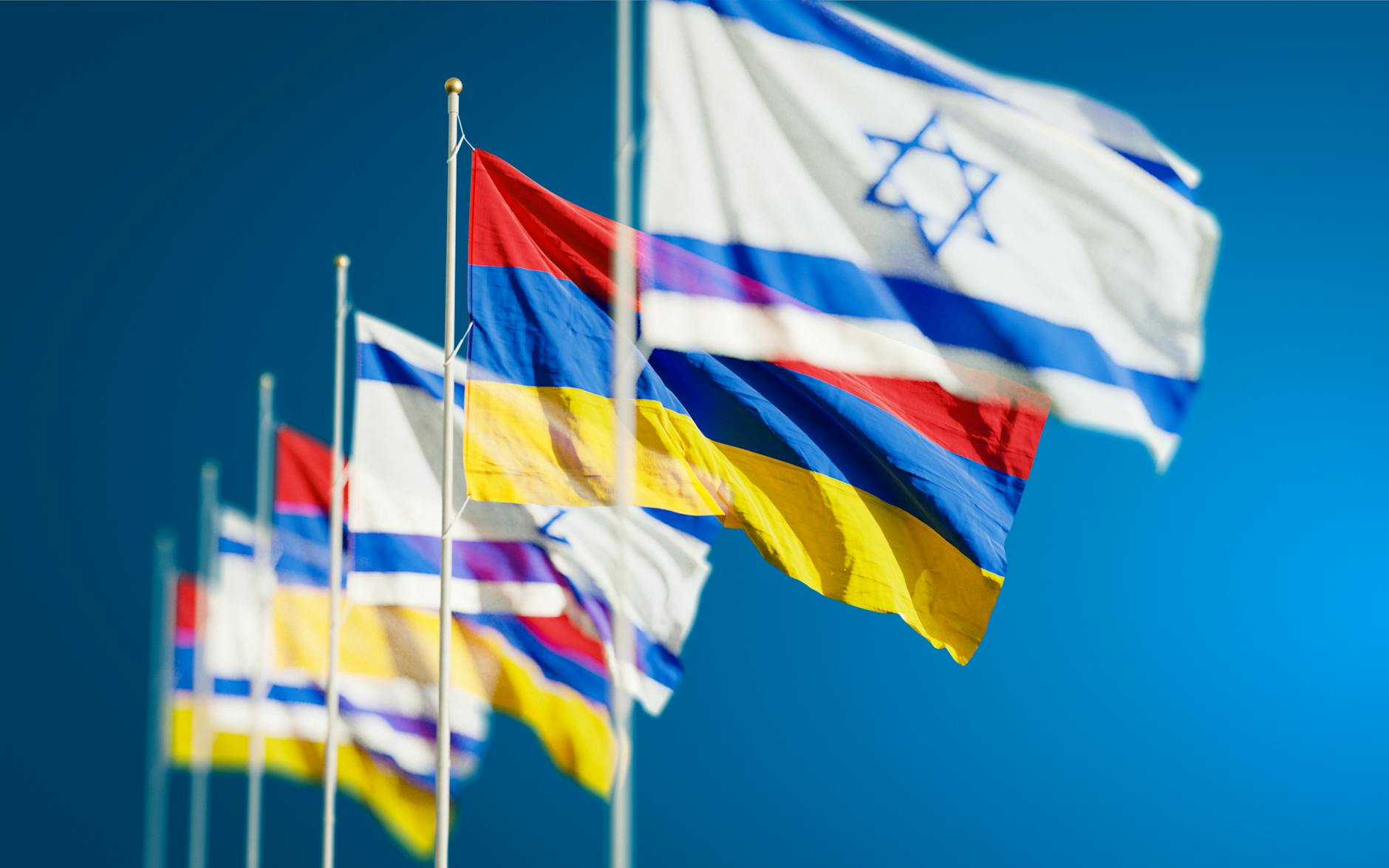 armenia and israel flags against blue sky